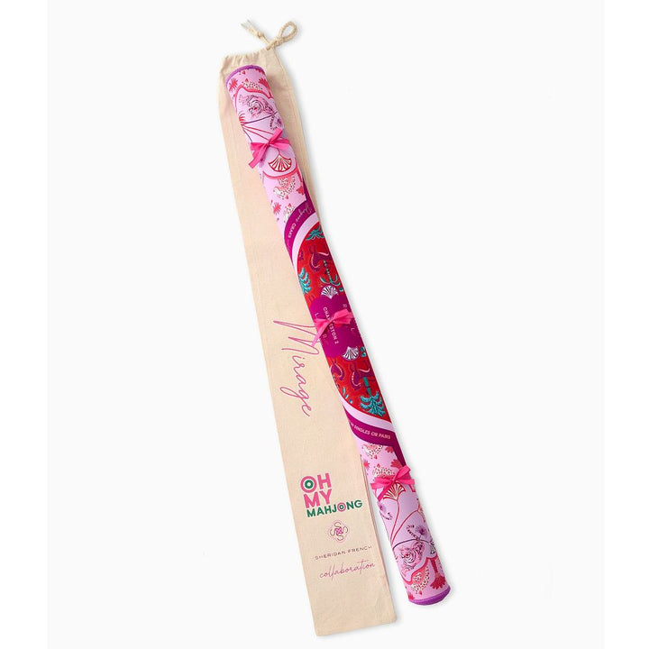 A rolled-up silk scarf in a beige drawstring pouch, featuring a vibrant pink and red floral pattern with the brand name &